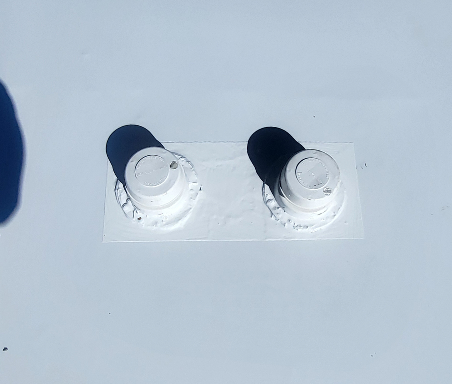 New TPO membrane and clean sealed plumbing vents on RV roof after replacement