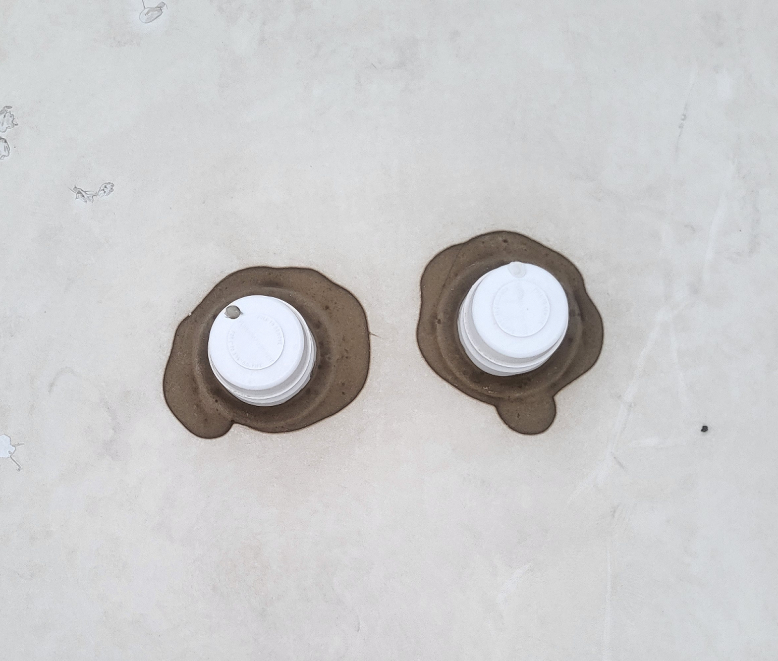 Old and dirty sealant around plumbing vents on RV roof before repair