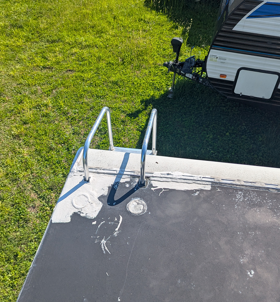 Aged RV roof and ladder mounts before PVC roof replacement
