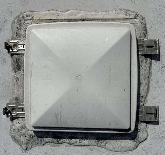 Damaged sealant around roof vent on RV before repair