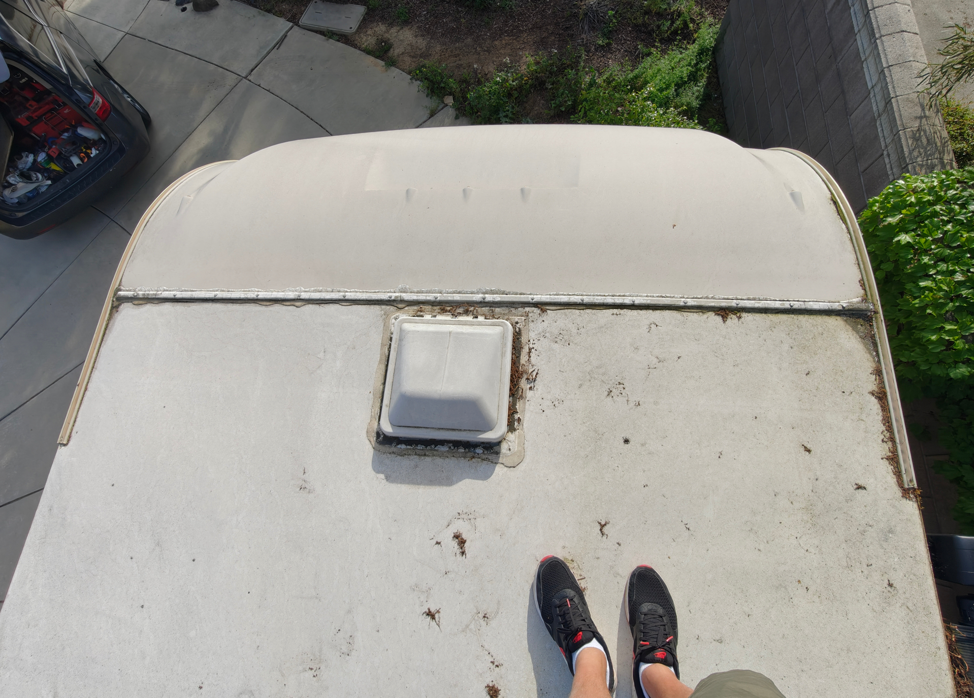 Loose termination bar and worn sealant around vent on RV roof before repair