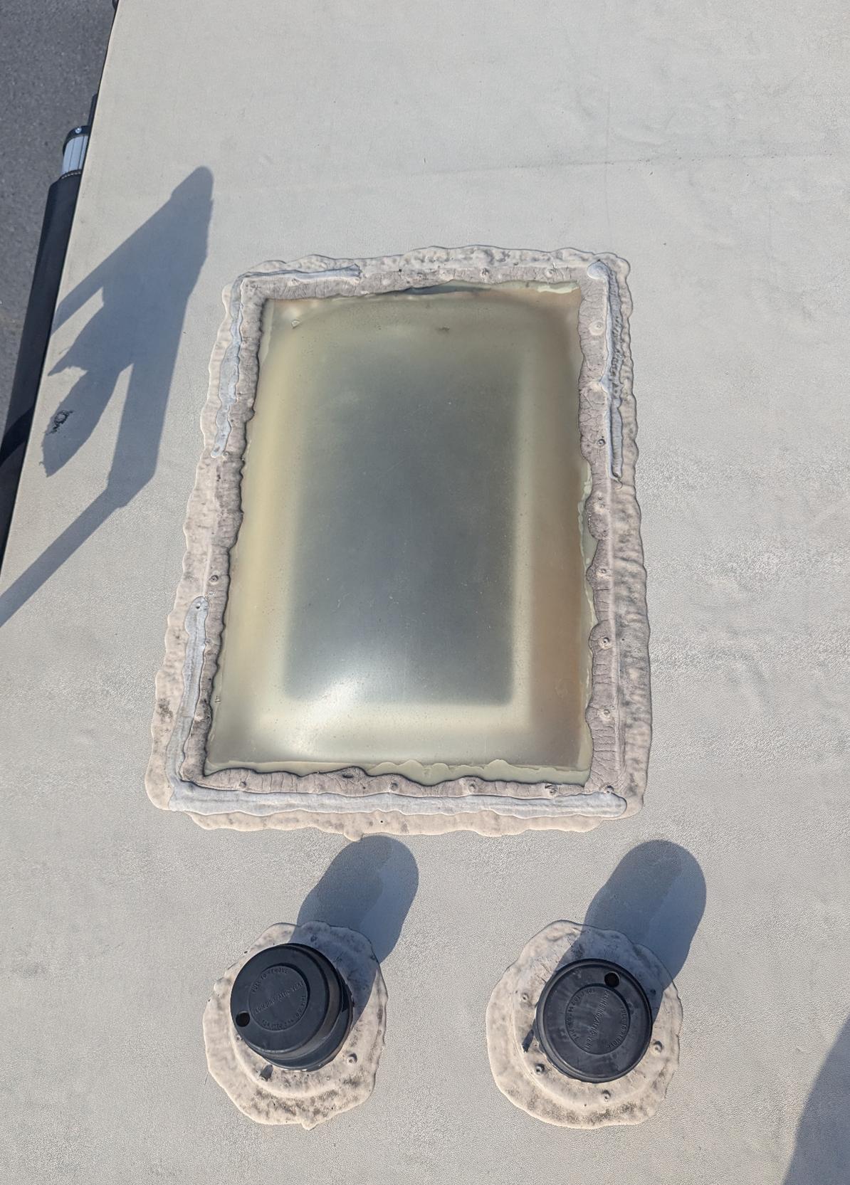Old RV skylight with worn sealant before roof replacement
