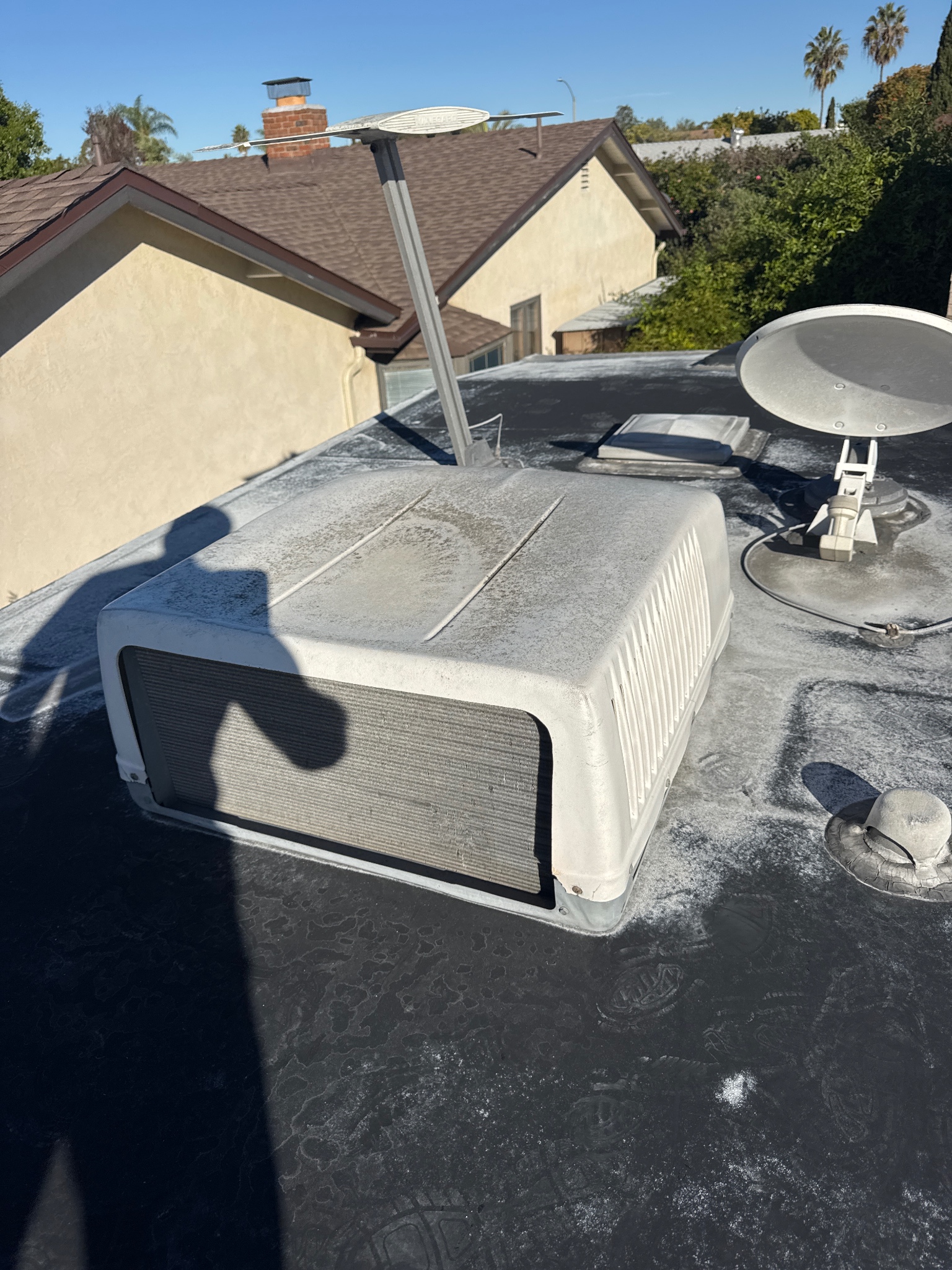 Worn sealant around AC unit on RV roof before repair