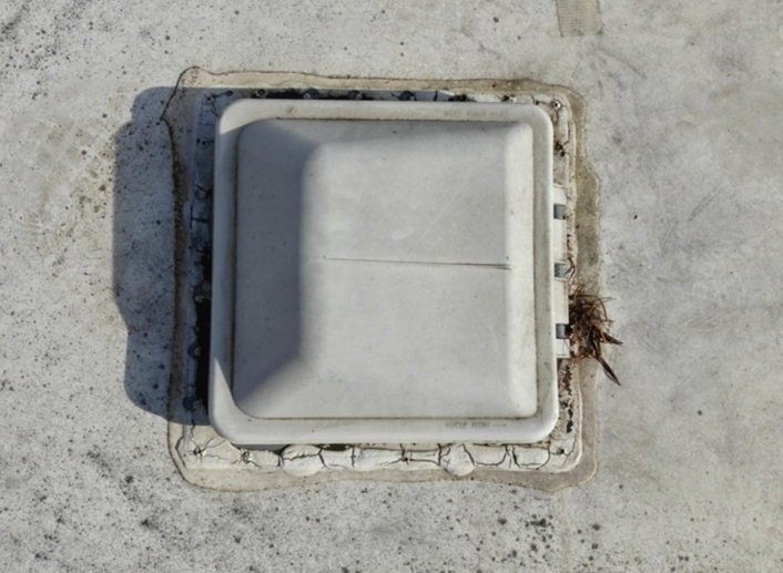Old and cracked sealant around roof vent on RV before maintenance