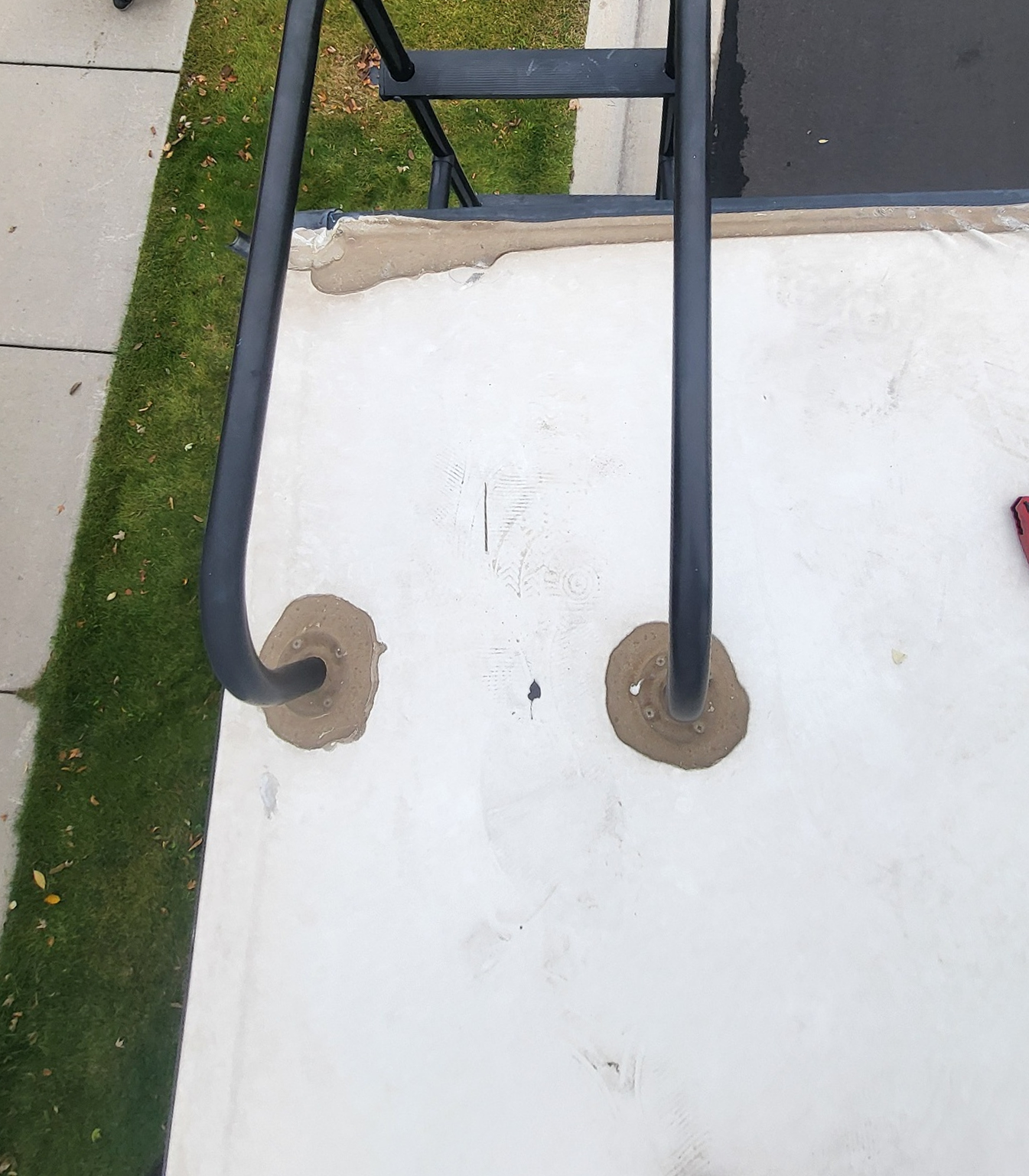 Worn and deteriorated sealant around ladder mounts on RV roof before repair